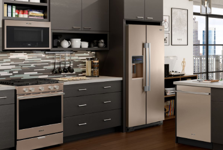 A kitchen with stainless steel appliances and wood flooring.